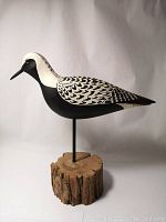 Side view of the Black Bellied Plover carving showing detailed black and white feather paint and wooden base.