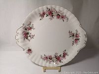 Full view of the Royal Albert Lavender Rose bone china cake plate showing scalloped edges, floral pattern, and integrated handle shapes.