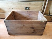 Front and inside view of the antique wooden crate showing wood grain, corner nails, and inner space.