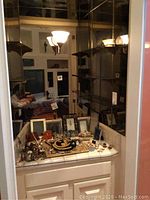 Vanity countertop with scattered jewelry, boxes and frames