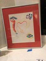 Full view of framed artwork, showing abstract design and red matting in white frame.