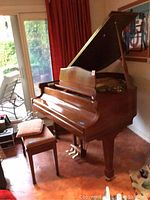 Three-quarter view of piano and bench in room with lid open