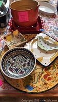 Overview of lot showing Mexican Lazy Susan, bamboo salad bowl, small floral bowls, Emily Henry red baking dishes and corn motif ceramic dish.