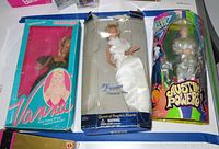 Three dolls with original boxes: Vanna White, Diana in white gown, Austin Powers in silver suit with colorful packaging