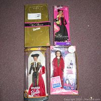 Overview of four Barbie dolls in original packaging: Winter Rhapsody Barbie, My Graduation Barbie, Spanish Barbie, and Rosie O'Donnell Barbie in boxes.