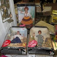 Photo showing all three I Love Lucy dolls in original boxes positioned on table.