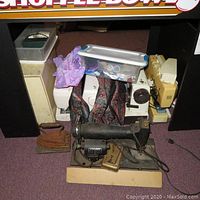 Image showing six sewing machines of various brands and conditions with some fabric, plastic containers and an old iron nearby.