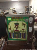 Full front view of Mini-Match coin operated soccer game machine in wood-grain cabinet with colorful game face and coin slot.