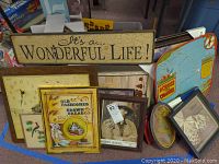 View of assorted vintage and inspirational wall hangings including sign, framed art, and clock