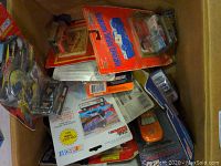 Box of assorted NASCAR die-cast cars in original packaging, with visible damaged and well-aged packaging