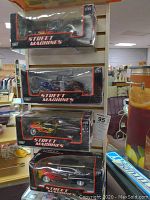 Four Street Machines die-cast cars stacked in their boxes on a shelf