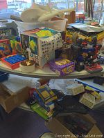 Overview of table with assorted boxes, cards, robots, and small collectible items containing Garfield cards and Star Wars games.