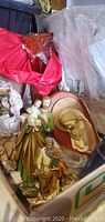 Photo showing several religious statues including Joseph with baby Jesus, an elderly bearded man reading, and a reclining Jesus plaque.