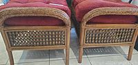 Front view showing the two brown wicker foot stools side by side, highlighting woven wicker details and cushion tops.