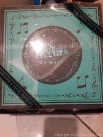 Closed original packaging showing Jean Paul Gaultier Le Male box with musical note decorations and label stating it is a real music box.