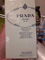 Front of the Prada Infusion d'Iris perfume box showing branding, scent name, and scent notes.