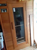 Exterior front view showing wood paneling, glass door and control panel