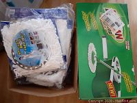 Box containing eight new spin mop heads, white microfiber pads, and the box of the spin mop system.