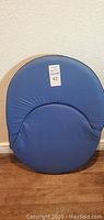 Blue portable folding floor chair front view showing round cushioned backrest and seat.