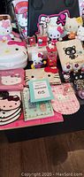 Grouped view of all Hello Kitty items showing bags, purses, perfume, and plush