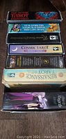 Top view of stacked tarot card boxes including Gothic Tarot, Cosmic Tarot, Renaissance Tarot, and others in a box.