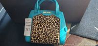 Front view of the teal leather handbag with leopard print fur panel and gold Just Cavalli logo.