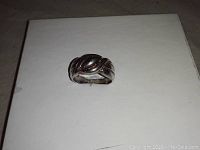 Photo of top view of vintage sterling silver ring with raised and etched design.