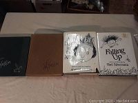 Four hardcover books by Shel Silverstein lined up on a table. The books are Where the Sidewalk Ends, Runny Babbit, A Light in the Attic, and Falling Up. Covers and dust jackets are shown.