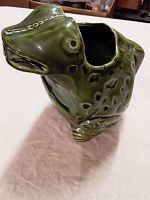 Side view of ceramic frog-shaped pitcher showing detailed frog head and body with a hole for pouring liquid.