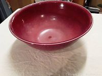 Front view of a deep red ceramic bowl with smooth finish.