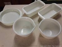 Five vintage milk glass cookware pieces shown on table: 2 rectangular baking dishes, 1 round baking dish, 2 mixing bowls