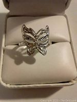 Close-up of sterling silver butterfly ring displayed in a ring box showing front design.