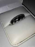 Ring angled in white jewelry box showing diagonal onyx stripe pattern