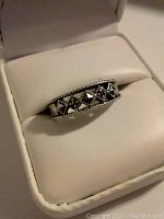 Close-up of sterling silver ring with hematite inlays in a jewelry box.