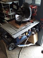 Side view showing Black & Decker miter saw mounted on Ryobi table saw and wheeled stand