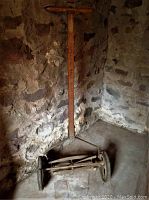 Full view of the manual grass cutter showing wooden handle, metal wheels and blade assembly