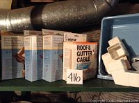 Five boxed roof and gutter cables and one box of Roof & Gutter Cable product on shelf