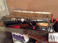 Metal toolbox opened showing assorted hand tools including sockets, screwdrivers, and pliers inside.