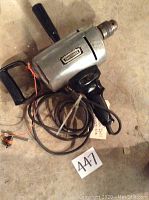 Side view of Craftsman Hole Hog 1/2 inch electric drill showing body, handle, cord and branding, placed on floor with lot tag 447.