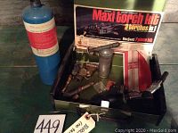 Full layout of Bernz-O-Matic torch kit including three torch heads, steel fuel tank, black torch handle, fuel canister, and original packaging box inside green metal carrying case