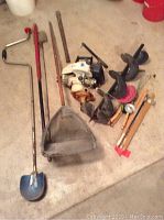 Full view of lot showing the ice auger with two large augers, spud bar, net, scooper, tip ups, and hand rods.