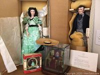 Wide shot of both dolls in original shipping boxes with ornament and diorama