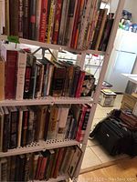 Front view of white metal shelving unit loaded with assorted books