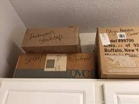 Boxes labeled "Induction stovetop", "Sealer" and part of Ninja pressure cooker box on top of cabinets