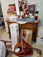 Overall lot on wooden dresser showing Rudolph tin, nutcracker, stuffed bears, plastic tray with lace, and gift boxes in background