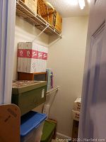 Closet shelf with white/red Toni doll boxes, green and blue storage bins