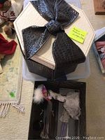 Closed hat box with black faux-croc bow on top