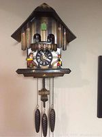 Full frontal view of chalet-style cuckoo clock hanging on wall