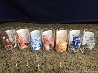 Front view of seven vintage glasses with colorful singalong characters on each glass