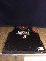 Front view of black Champion basketball jersey with Philadelphia 76ers Sixers logo and number 3.